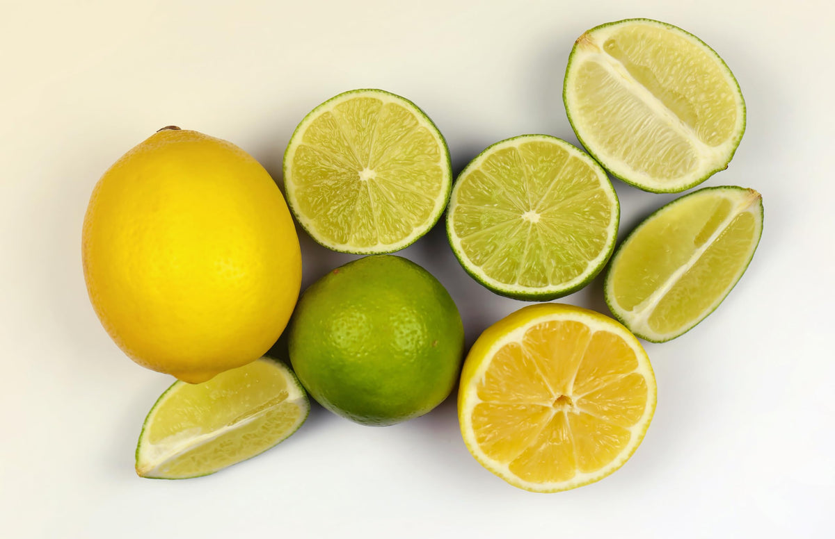 Whole and sliced yellow and green citrus fruits.
